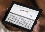 An illustration picture shows a woman holding her Apple Ipad which displays a tactile keyboard under the Google home page in Bordeaux
